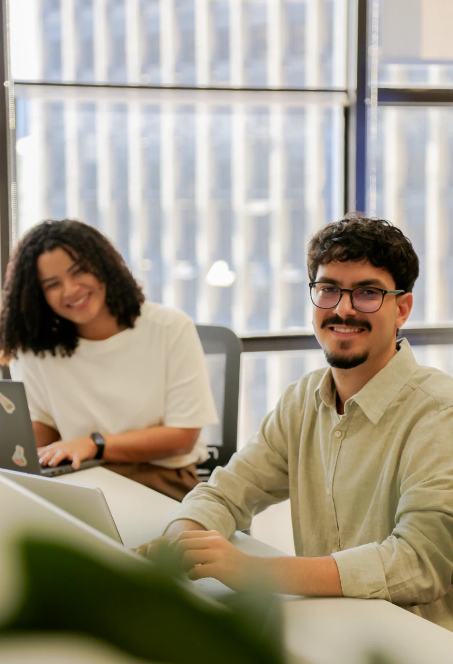 Dois estagiários da AXIA Energia trabalhando no escritório